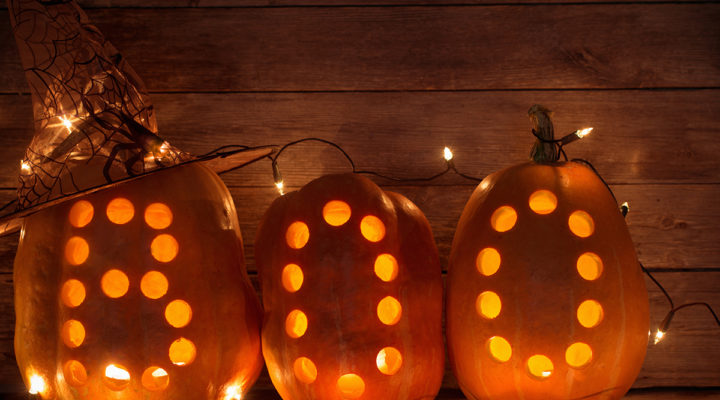 Three lighted pumpkins carved with the letters 'BOO"